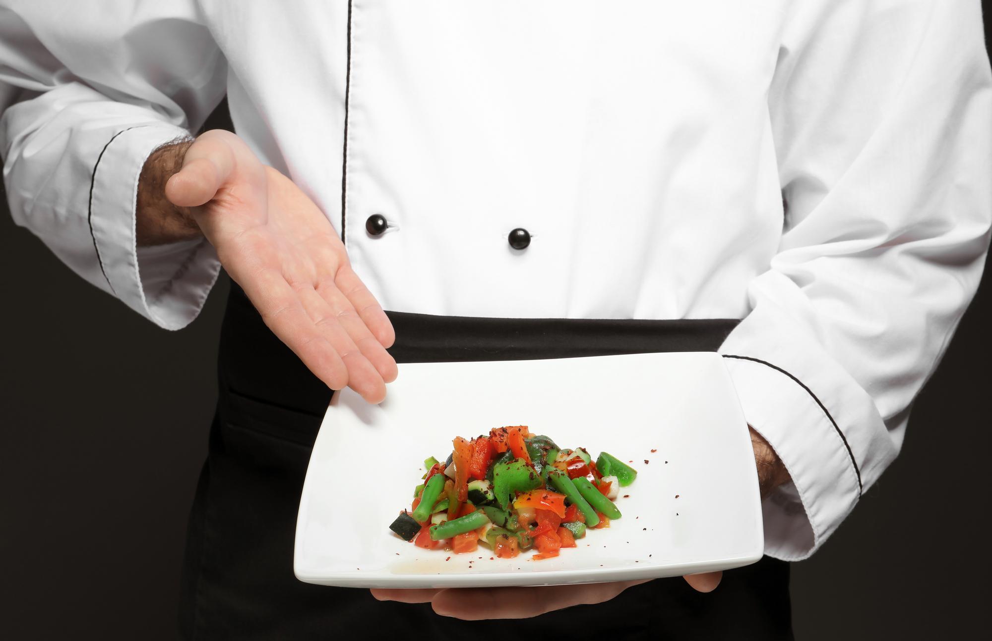 Chef elegante prepara un piatto in cucina di design